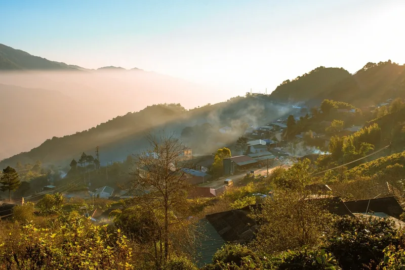 Morning mist and golden sunlight drift over a mountain village in Ta Xua, Son La.